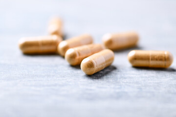 Korean Ginseng capsules. Concept for a healthy dietary supplementation. Wooden background. Soft focus. Close up.