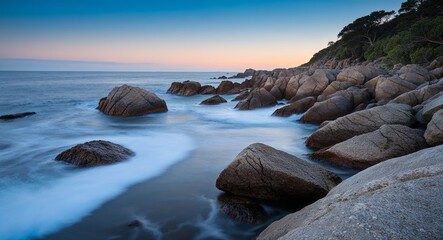 Coastal rocks with gentle waves at daybreak enhancing the tranquility of the scene