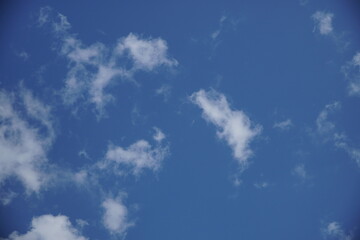 Clear blue sky with a few clouds. The sky is very bright and the clouds are scattered throughout