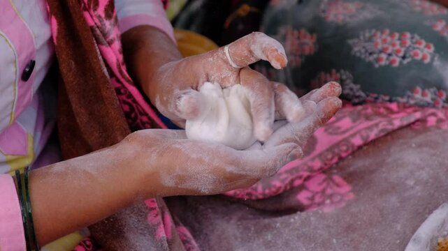 Woman making sweet rice modak stuffed with grated coconut and jaggery, Steamed or ukdiche Modak. It's a traditional sweet dish made out of coconut, jaggery