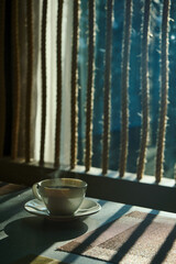 a morning hot coffee in white cup in sunshine scene with shade and white smoke from hot water