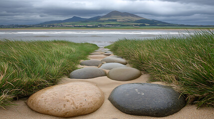 A landscape photo with large stones forming a path toward a mountain and sky. 
