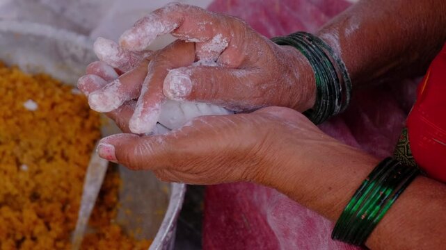 Woman making sweet rice modak stuffed with grated coconut and jaggery, Steamed or ukdiche Modak. It's a traditional sweet dish made out of coconut, jaggery