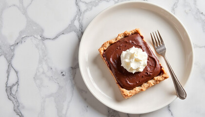 Chocolate pie slice with whipped cream on marble plate