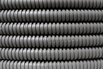 Abstract background depicting row grey corrugated plastic pipes in warehouse.