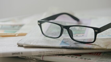 A close up of the glasses on the newspaper.