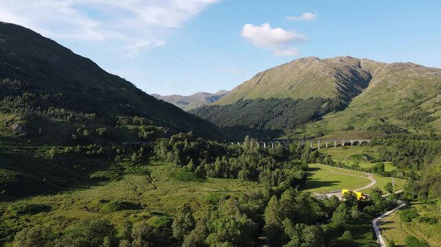 Experience the magic of the Glenfinnan Viaduct as a train gracefully traverses this iconic structure, set against the backdrop of the stunning Scottish Highlands