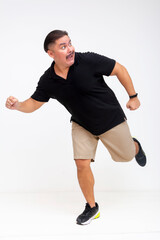 A terrified middle-aged man fleeing while looking back, running away to save his life. Showing...
