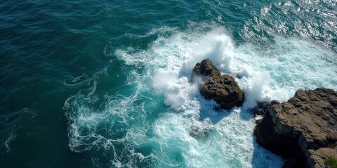Ocean's Fury: A dramatic aerial view of powerful waves crashing against rugged rocks, showcasing the raw energy and beauty of nature's untamed force.  