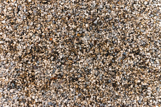 Smooth round pebbles texture background. Pebble sea beach close-up, dark wet pebble and gray dry pebble. natural gravel, texture from gravel. Gravel texture. Pebble stone background.