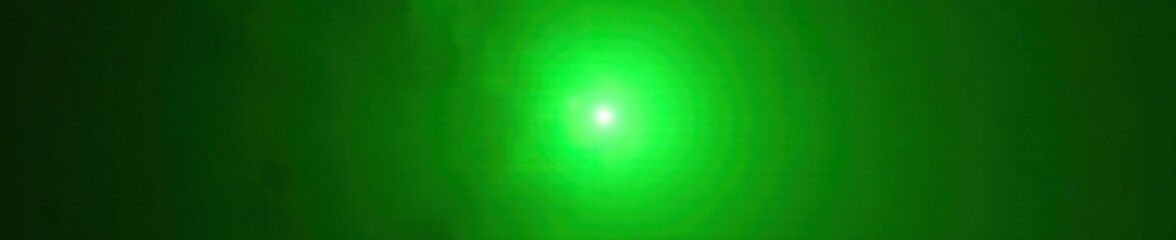 Obraz premium Bright green lens flare against dark backdrop, sunspot, glowing spot, bright green
