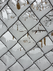 winter at countryside - wire-mesh fence covered by white snow