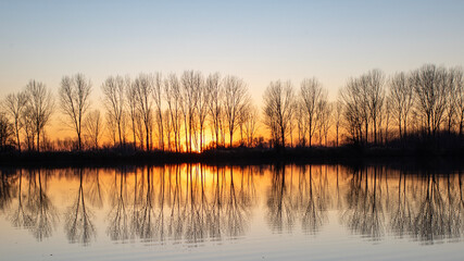 tramonto all'orizzonte riflesso nell'acqua del lago