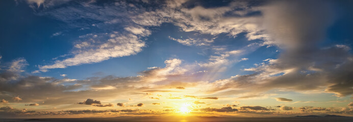 Fototapeta premium A beautiful sunset sky with yellow and orange colours as a background or texture