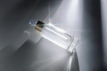 Bottle of face serum with a pipette with a beautiful highlight.