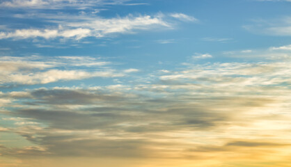 A beautiful sky tinted by the sun leaving vibrant shades of gold, pink, blue and multicolored. Clouds in the twilight evening and morning sky. Cloudy sky background in the evening, and during the day.