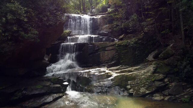 Rising drone shot of Little Bradley Falls, a waterfall in the forest of North Carolina in the Great Smoky mountains.