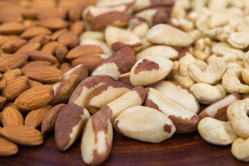 Mix of nuts on a wooden plate. Nuts mix background.
