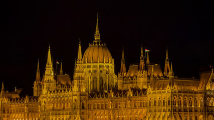 Fototapeta premium Illuminated at night, the Hungarian Parliament Building in Budapest represents architectural grandeur, making it ideal for European travel themes
