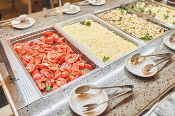Fresh tomatoes and mimosa salad, traditional dishes in metal containers, a buffet with Russian dishes. With space to copy. High quality photo