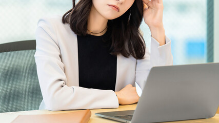 頭を押さえて悩む女性・ビジネスウーマン