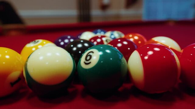 Closeup of lines up Pool balls under warm glow lights on a red table in a cozy game room