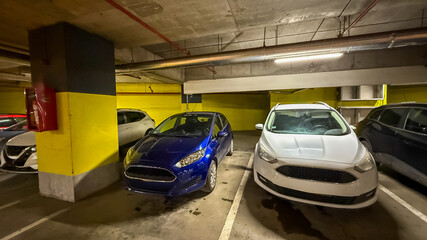 Obraz premium Cars parked in an underground garage, highlighting urban parking challenges in a modern city environment