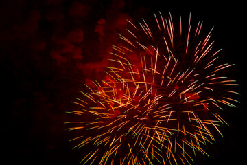 Multicolored purple gold bright sparks of fireworks on black sky