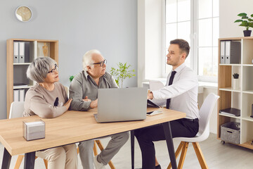 Financial adviser and agent in consultation with a senior couple in office. The discussion covers insurance, financial planning, real estate purchases, and investment strategies.