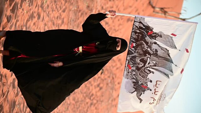 In the desert, a Saudi woman in elegant traditional attire celebrates Founding and national day with pride, embodying heritage, Waving founding flag. Vertical video