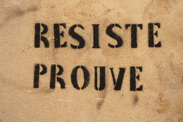 Resiste prouve writing on ochre wall