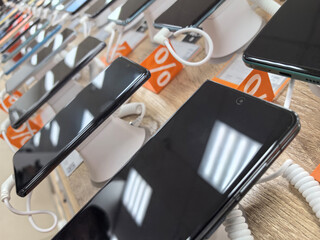 Display of modern smartphones with promotional offers in a retail store