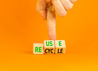 Reuse or recycle symbol. Concept words Reuse Recycle on wooden block. Beautiful orange table orange background. Businessman hand. Business reuse or recycle concept. Copy space.
