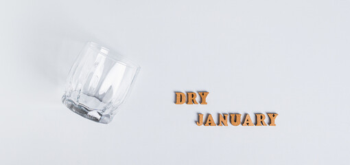 Sober January concept, empty glass and text on grey background top view web banner