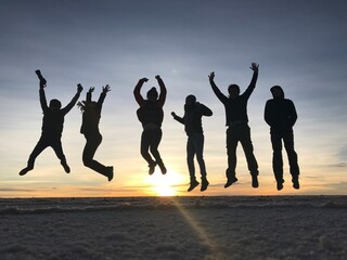 silhouettes of people jumping in the sunrise