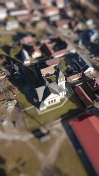 Aerial Tilt-Shift View of a Church in a Quaint Village Landscape with Rotating Top-Down Perspective