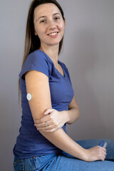 Girl sitting with sensor glucose patch on her arm