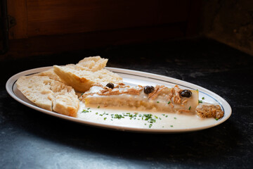 Pancakes that tuna, duck or chicken served with bread and spices on a dark stone, with white cheese sauce on an angled