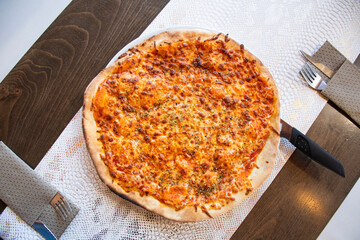 margherita pizza with cheese and homemade tomato sauce in a restaurant top view with cutlery on the table top view