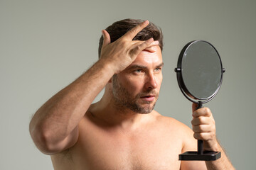 guy standing in modern bathroom at home. Male Beauty And Haircare Routine. Handsome Man Touching...