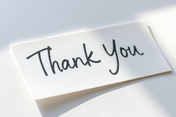 Fototapeta premium A stylish thank you banner rests gently on a light surface, showcasing heartfelt appreciation. The handwritten message conveys warmth and sincerity perfect for any occasion