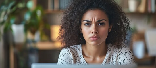 Young woman displaying frustration and confusion over computer issues at work with a serious expression and room for text overlay