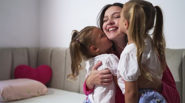 Joyful mother embraces her daughters in a warm, heartfelt moment at home. Concept of maternal love, happiness, and family bonding