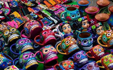 Obraz premium Street sale of handicrafts alluding to the Day of the Dead in Mexico City. Cups decorated with colorful skulls. Frida cups.