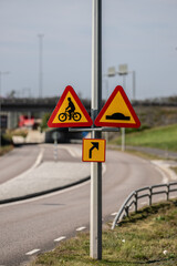 Signs warning for crossing bicycle lane and speed bump.