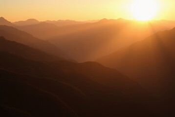 Obraz premium Golden Sunset Over Majestic Mountain Range