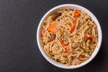 Delicious fresh pilaf with rice, carrots, meat, onions, spices and berries