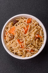 Delicious fresh pilaf with rice, carrots, meat, onions, spices and berries