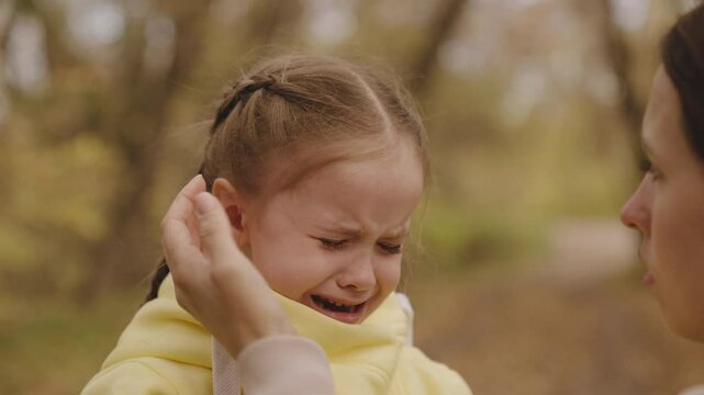 child crying. close-up face. tears eyes little kid girl. unhappy upset child. mother calms child daughter. feeling pain face tearful, capricious child. wet tears run down cheek little frustrated kid