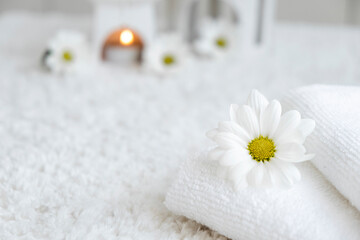 White towels with chamomile and aroma lamp, candle on background. Spa resort therapy and wellness, aromatherapy relaxation. Body care and treatment. Self Love. Copy space.